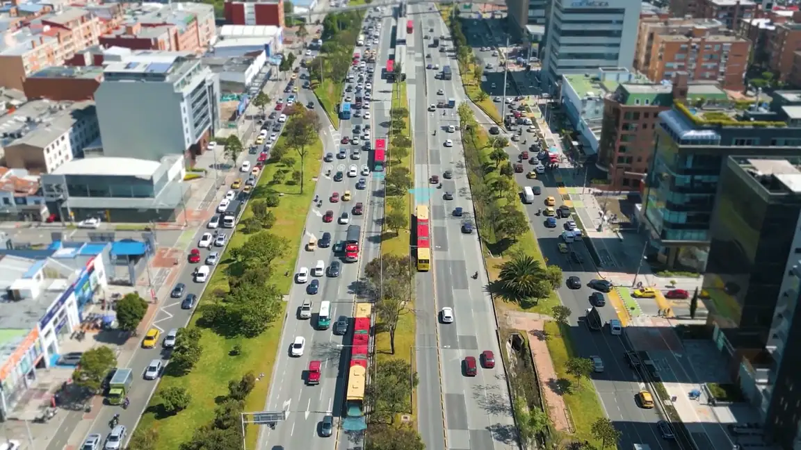 Corredor urbano en hora punta visto desde el aire, con buses articulados en su carril exclusivo.